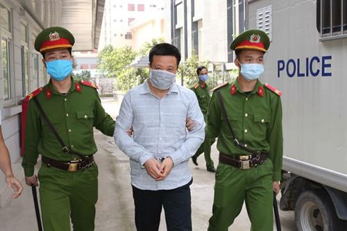 被告何文深被公安人员押解到法院受审。图自越通社 被告何文深被公安人员押解到法院受审。图自越通社