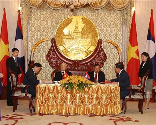 越共中央总书记、国家主席阮富仲与老挝人民革命党中央总书记、国家主席本扬·沃拉吉出席两国政府和各部委之间合作文件的签字仪式。图自越通社