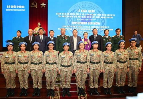 二号二级野战医院女士兵（前排）同各位领导合影。图自越通社