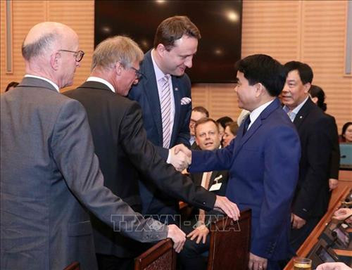 河内市人民委员会主席阮德钟与与会代表握手。图自越通社