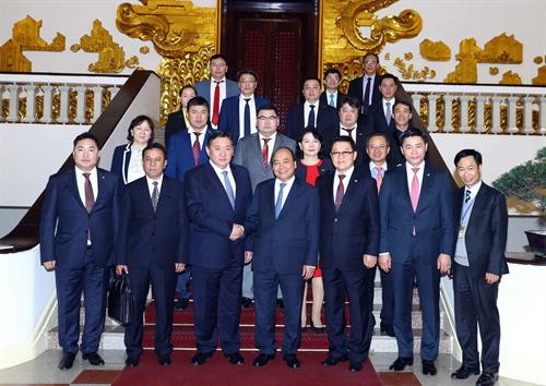 越南政府总理阮春福和蒙古国家大呼拉尔主席米耶贡布·恩赫包勒德一行合影。（图片来源：越通社）