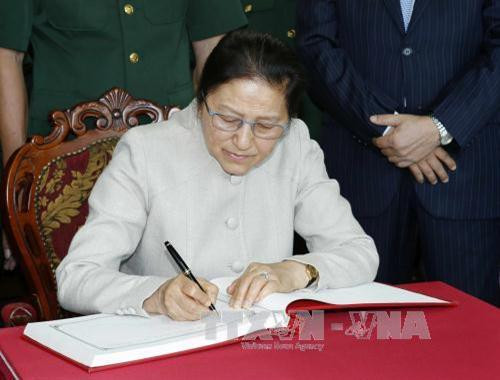 巴尼·亚托杜在11号军团留言簿上写留言。（图片来源：越通社）