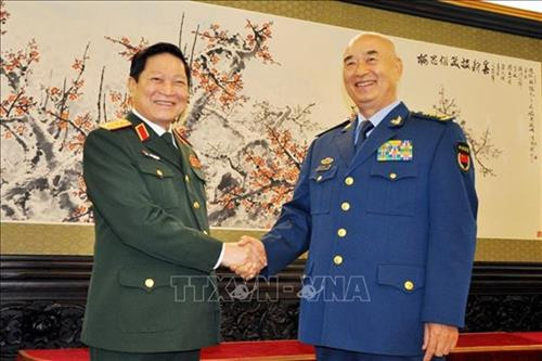 吴春历(左)会见许其亮。图自越通社 吴春历(左)会见许其亮。图自越通社