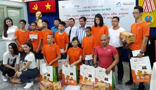 步行活动的赞助商向橙剂受害者赠送慰问品。（图片来源：sggp.org.vn）