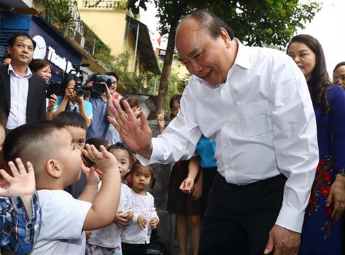 阮春福总理微笑着同小孩子们打招呼。图自越通社