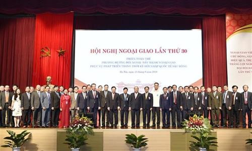 各位代表在15日上午召开关于对外工作方向的全体会上合影。图自越通社