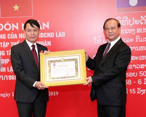 老挝信息、文化和旅游部长波显坎·冯达拉(右)向越通社社长阮德利个人授予老挝二等自由勋章证书。图自越通社