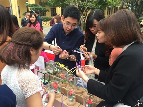 越南青年被中国手工艺品吸引住（图片来源：人民军队报）