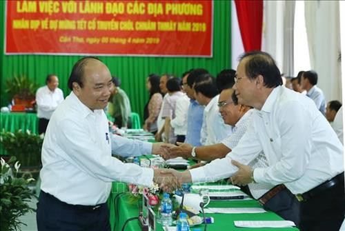 越南政府总理阮春福同与会代表握手。图自越通社