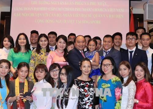 阮春福与夫人已同越南驻新加坡大使馆工作人员、旅新越侨社群代表合影留念。越通社记者 统一 摄