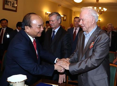 阮春福与俄罗斯援越老军事专家握手。图自越通社