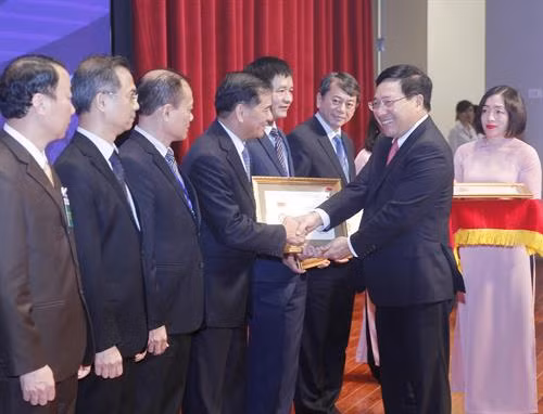 政府副总理兼外长范平明向各省市领导颁发致力于外交事业纪念章。（图片来源：越通社）