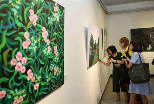 参观摄影展上展示的作品 图自越通社