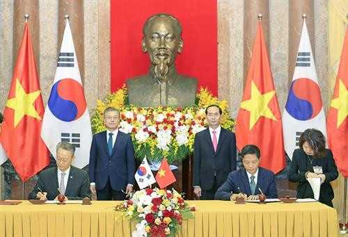 越南国家主席陈大光和韩国总统文在寅出席双方合作文件签字仪式。（图片来源：越通社）