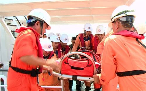 搜救人员把遇险渔民救助上岸。图自越通社 搜救人员把遇险渔民救助上岸。图自越通社