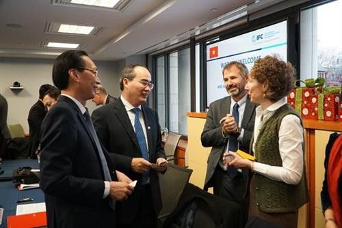阮善仁和胡志明市领导代表团同国际金融组织代表交谈。（图片来源：越通社）