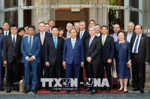 阮春福同大型跨国集团及公司领导合影。（图片来源：越通社）