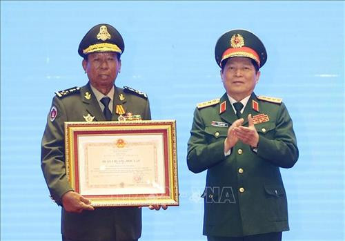 吴春历大将受越南国家主席的委托向柬埔寨国防部长迪班大将授予一等独立勋章。图自越通社