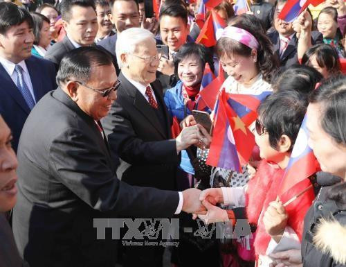 阮富仲和老挝人革党中央总书记、国家主席本扬·沃拉吉与首都河内居民握手。越通社记者 芳花 摄