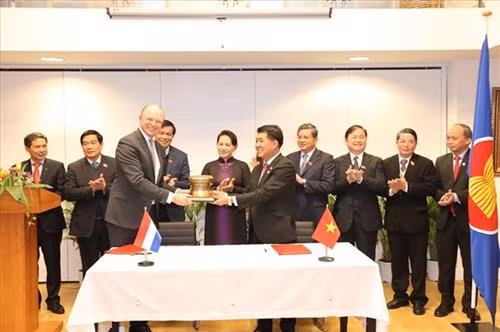 荷兰德赫斯(De Heus)集团代表（左）与平福省雄仁集团总裁武孟雄（右）递交合作文件。图自https://laodongtre.laodong.vn