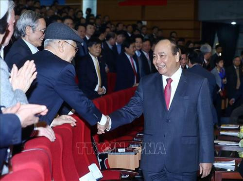越南政府总理阮春福和与会代表握手。图自越通社
