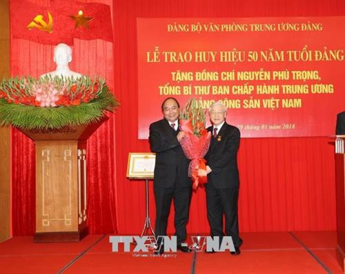 越南政府总理阮春福向阮富仲赠送鲜花。（图片来源：越通社）