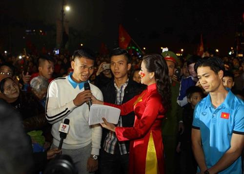 乂安省数万名球迷拿着金星红旗、横幅标语迎接该省U23足球队4名球员。（图片来源：越通社）