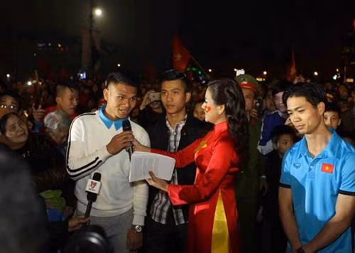 乂安省数万名球迷拿着金星红旗、横幅标语迎接该省U23足球队4名球员。（图片来源：越通社）