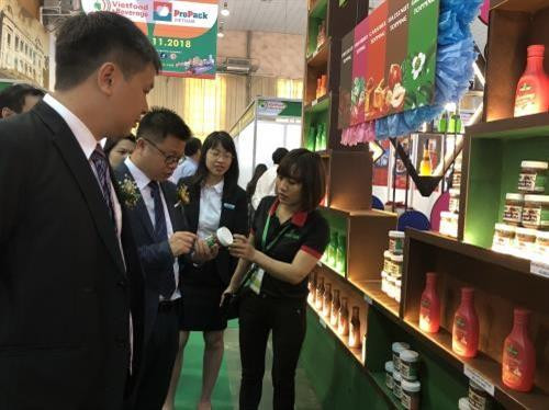 企业代表向参观者介绍各种产品。图自越通社