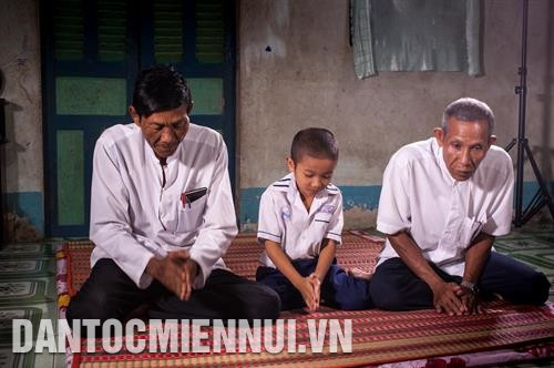 朔庄省州成县富心乡安协村高棉族人山国盛（7岁）正与两位和尚（Achar）学佛经。记者 文玉 摄