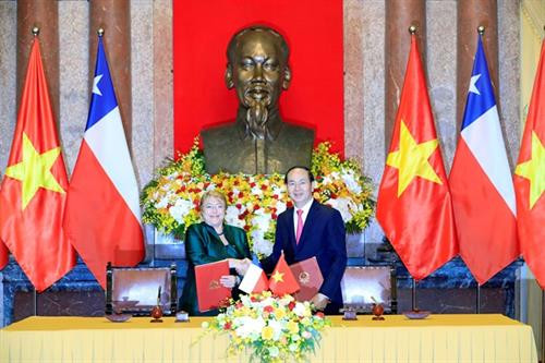 越南国家主席陈大光和智利共和国总统米歇尔·巴切莱特·赫里亚签署联合声明。（图片来源：越通社）