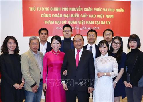 越南政府总理阮春福携夫人同在挪威就读的越南留学生代表合影。图自越通社