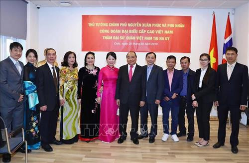 越南政府总理阮春福携夫人同越南驻挪威大使馆工作人员合影。图自越通社