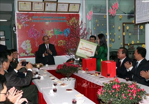 阮春福前来拜年岘港市海州郡顺福坊。图自越通社
