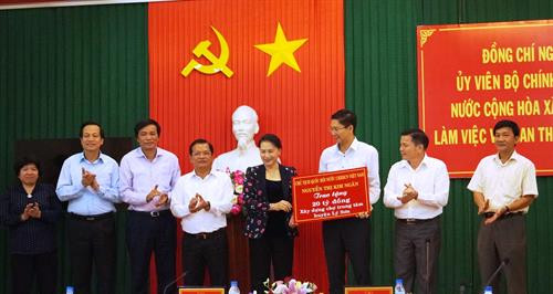 阮氏金银向广义省李山岛县县委书记阮曰微赠送从越南国家银行和工贸部筹集到的200亿越盾。（图片来源于网络）