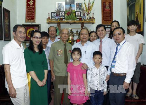 阮春福与伤残老兵阮青林家属合影纪念。(图片来源:越通社) 阮春福与伤残老兵阮青林家属合影纪念。(图片来源:越通社)