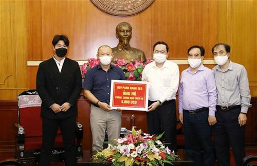 越南国家足球队主教练朴恒绪向越南祖国阵线中央委员会转交其为新冠肺炎疫情防控工作捐赠的5000美元援助资金。图自越通社