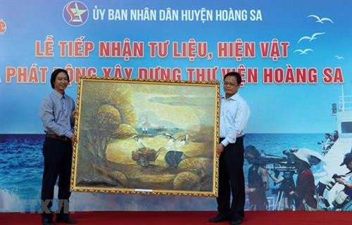 黄沙县人民委员会主席武玉铜接受个人和组织捐赠的实物和资料。图自越通社