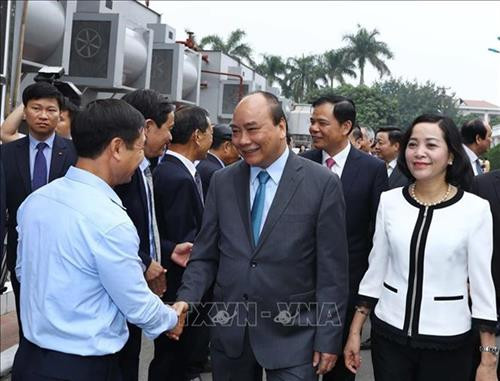 越南政府总理阮春福走访同交出口食品股份公司的生产经营活动。图自越通社