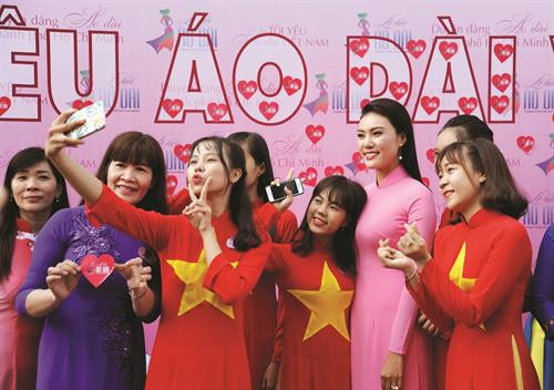 身穿奥黛的胡志明市居民和青年人与形象大使合影留念。记者 安孝 摄