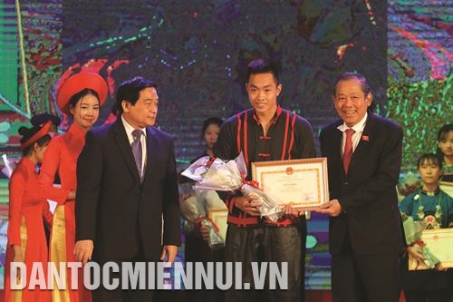 越共中央政治局委员、政府常务副总理张和平，越共中央委员、国会民族委员会主任杜玉战向夺得东南亚班卡苏拉锦标赛铜牌的巴天族学生扶泰越颁发奖状和送上鲜花。