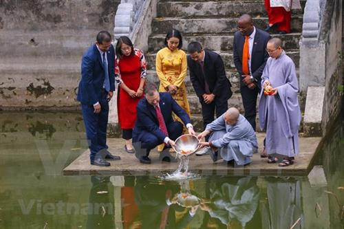 美国驻越南大使丹尼尔·克里滕布林克放生鲤鱼送灶君上天庭。图自越通社