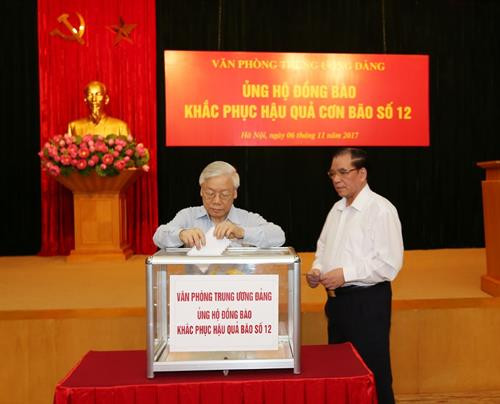 越共中央总书记阮富仲、原越共中央总书记农德孟向灾区人民提供捐款。（图片来源：越通社）