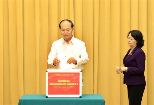 国家主席陈大光、副主席邓氏玉盛向灾区人民提供捐款。（图片来源：越通社）