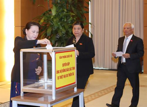 阮氏金银同国会办公厅工作人员向灾区人民提供捐款。（图片来源：越通社）