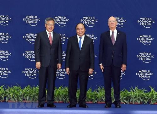 越南政府总理阮春福（中）与世界经济论坛创始人兼执行主 席克劳斯· 施瓦布（右）及中华人民共和国国务院副总理胡春华（左）出席会议。图自越通社