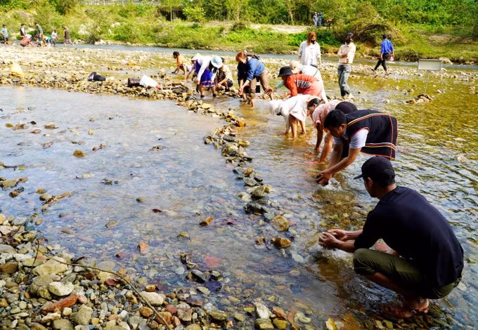 数百人涌向长河，兴高采烈地轮流搬运石块，堆砌成拦截水流的石坝。