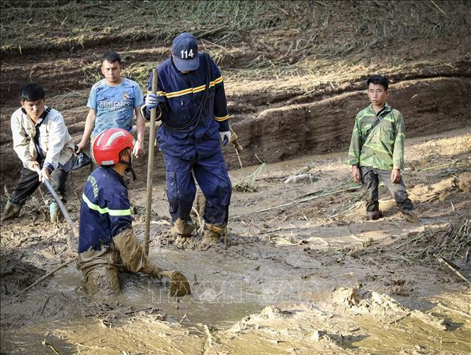 村长莫阿诗(右一)和职能力量配合在奠边省车容乡杭普喜村搜寻失踪者。图自越通社 potal-dien-bien-khan-truong-hoan-thien-thu-tuc-khen-thuong-truong-ban-mua-a-thi-stand-1.jpg