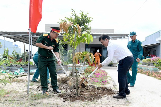 西宁省人民委员会代主席阮鸿成（右）在周城县和会乡波楞村常驻民兵哨所植树。图自越通社