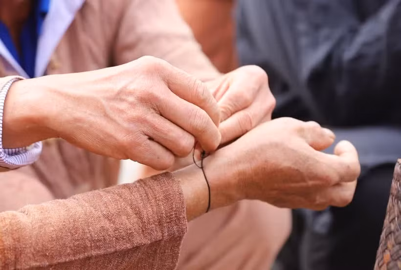 在手腕上绑过线的人须将其一直佩戴在身，任何场合都不可取下，直至次年的迎雷仪式为止。图自越通社